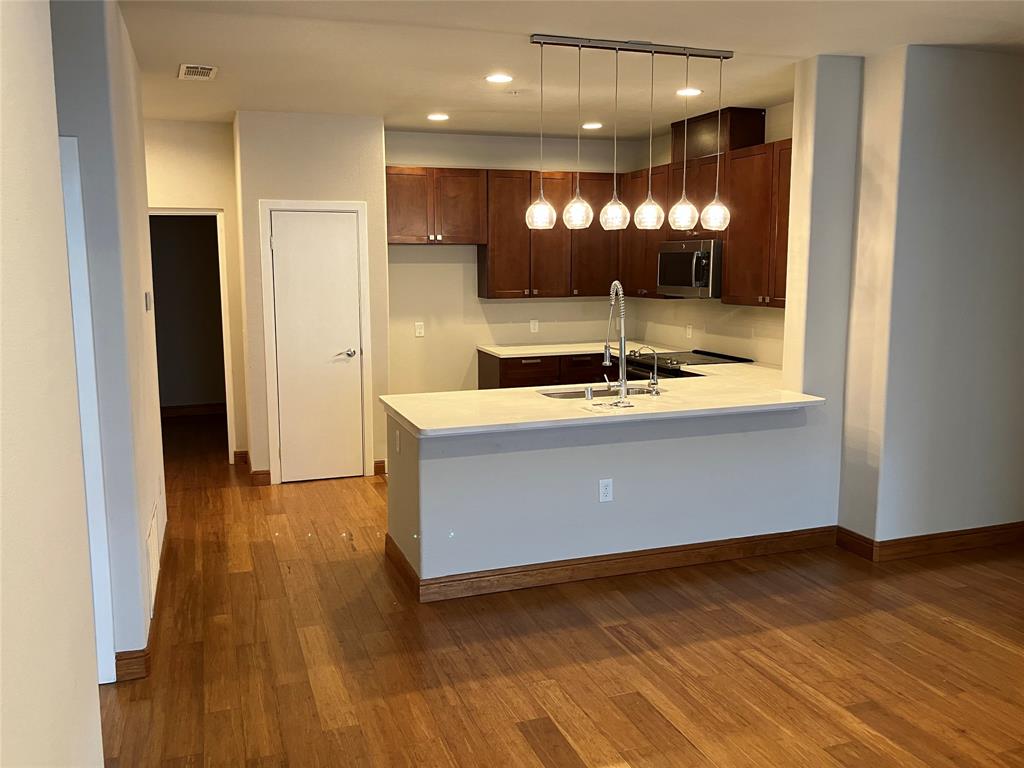 1220 West Trinity Mills Road, Unit 5009 Carrollton, TX 75006 - Photo 3 of 25 a room with wooden floor and a large mirror