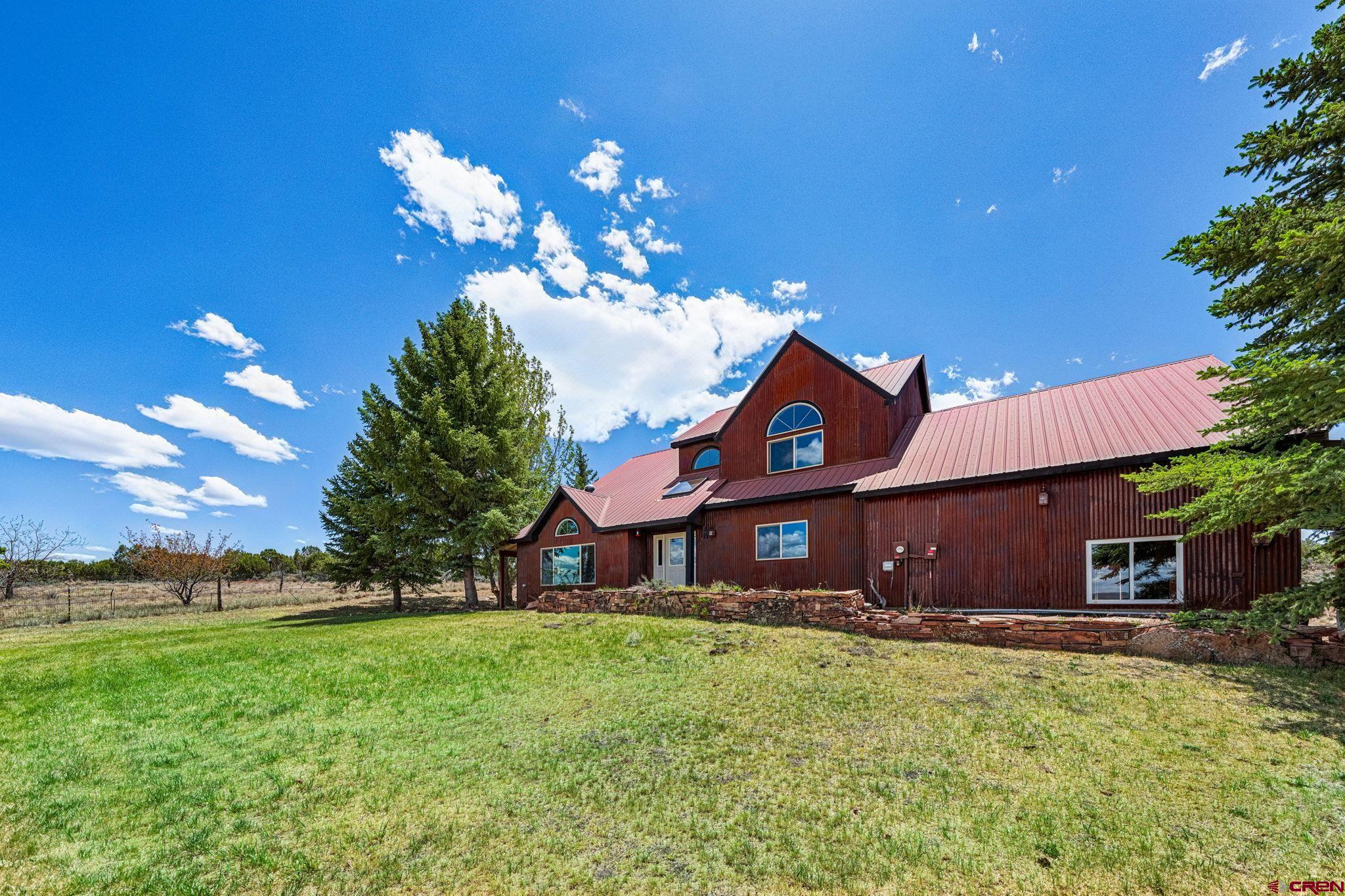 22480 Rd L Cortez, CO 81321 - Photo 31 of 44 a front view of a house with a yard and a garage