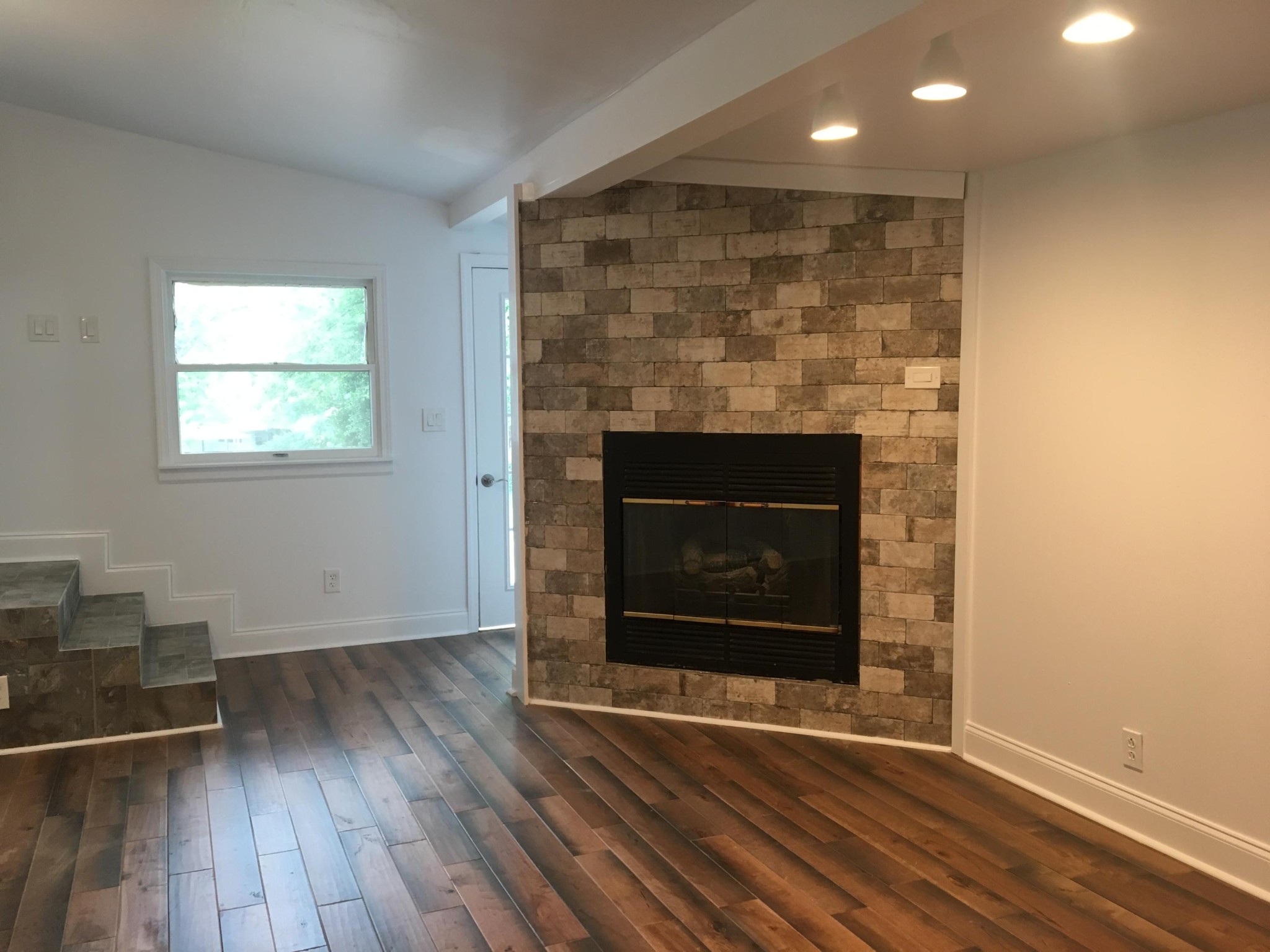 107 Pembroke Road Oak Ridge, TN 37830 - Photo 8 of 28 an empty room with wooden floor fireplace and windows