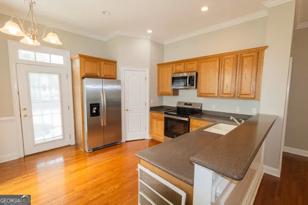 a kitchen with stainless steel appliances granite countertop a refrigerator a stove top oven a sink with granite countertops and cabinets