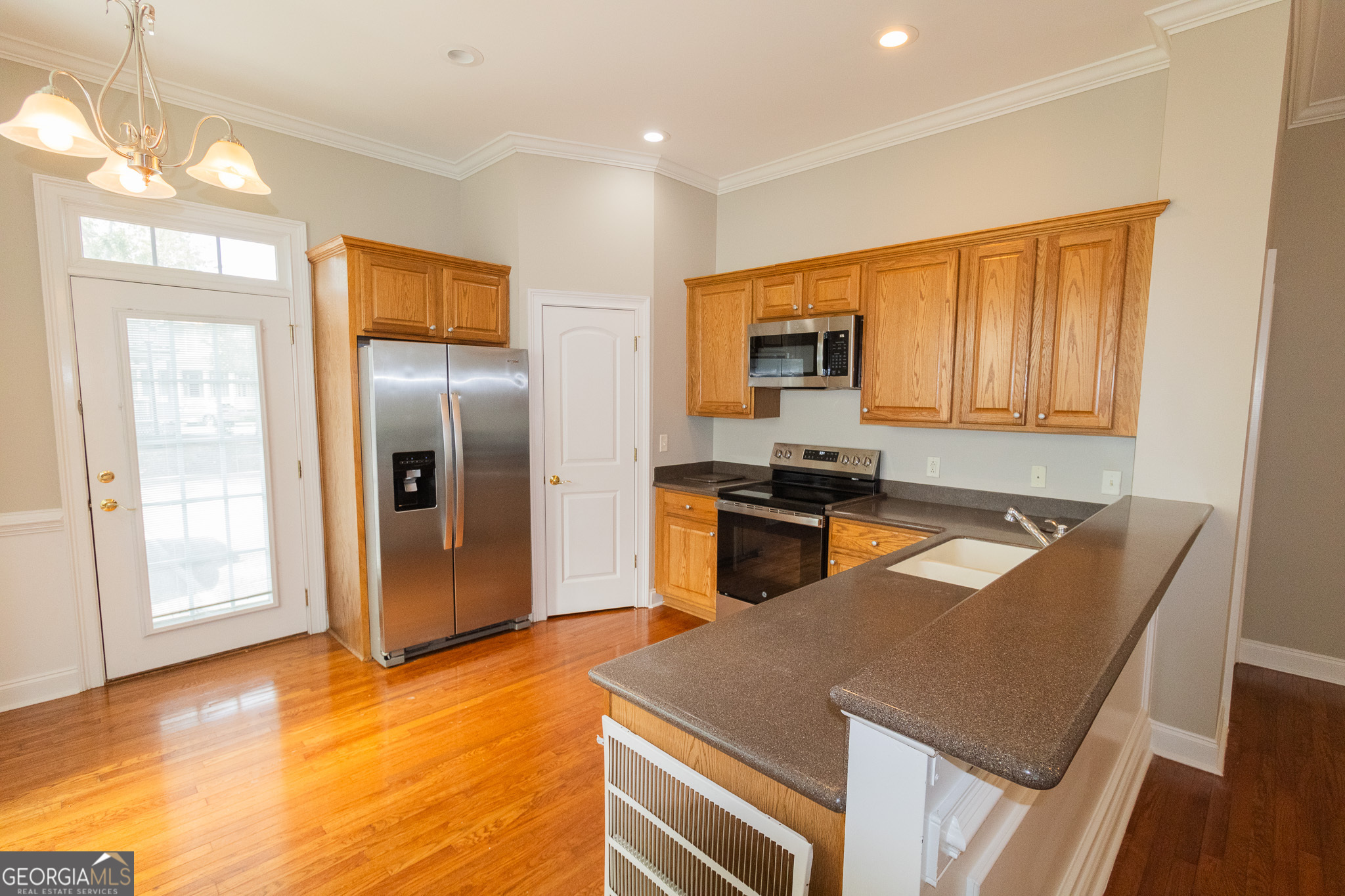121 Tillman Road, Unit 301 Statesboro, GA 30458 - Photo 5 of 8 a kitchen with stainless steel appliances granite countertop a refrigerator a stove top oven a sink with granite countertops and cabinets