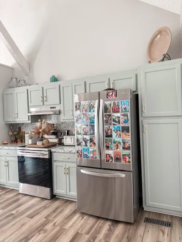 a kitchen with refrigerator and cabinets