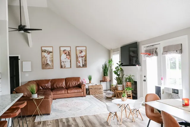 a living room with furniture a flat screen tv and a table