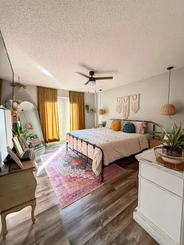 a bedroom with a bed a dresser and a window