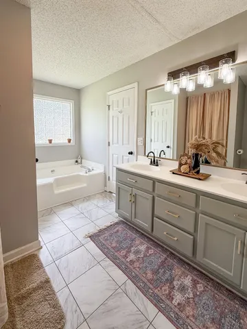 a spacious bathroom with a sink mirror and a bathtub