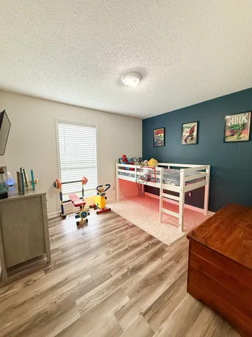 a bedroom with furniture and a wooden floor