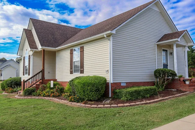 a front view of a house with a yard and plants