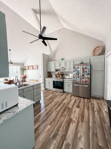 a kitchen with stainless steel appliances granite countertop a refrigerator and a stove top oven