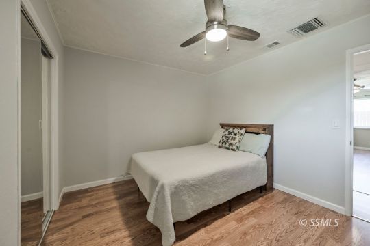 1233 Mayo Street Ridgecrest, CA 93555 - Photo 22 of 32 a bedroom with a bed and a chandelier