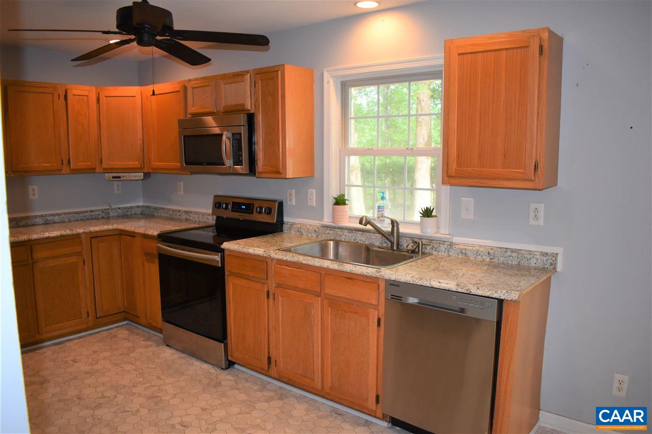334 East Daffodil Road Ruckersville, VA 22968 - Photo 20 of 50 a kitchen with stainless steel appliances granite countertop a sink a stove and a microwave