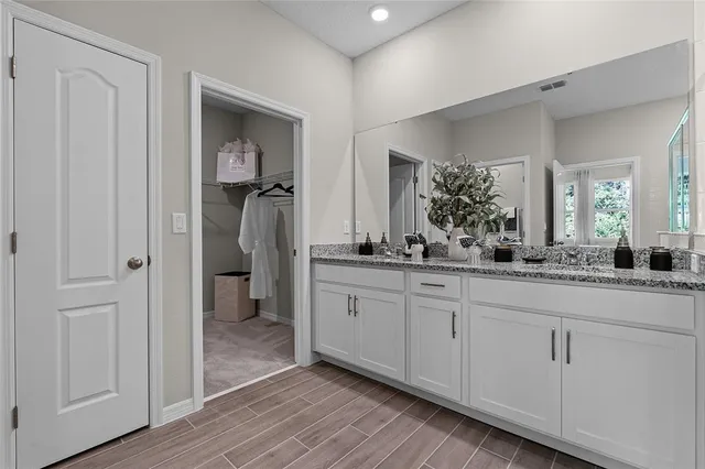 a spacious bathroom with a granite countertop sink and a mirror