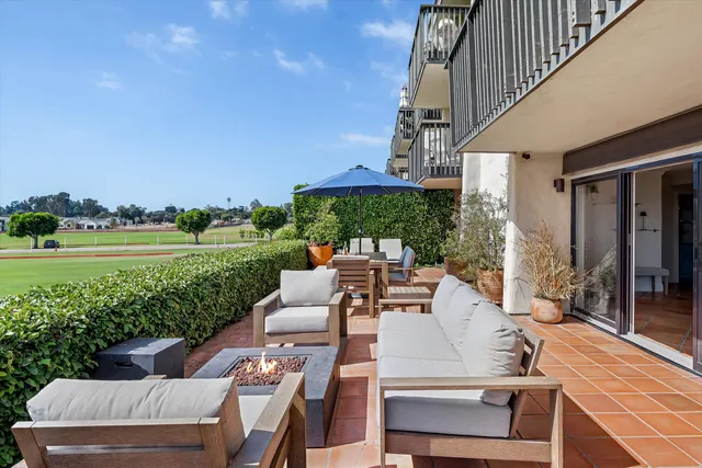 a view of a patio with couches table and chairs with plants and garden