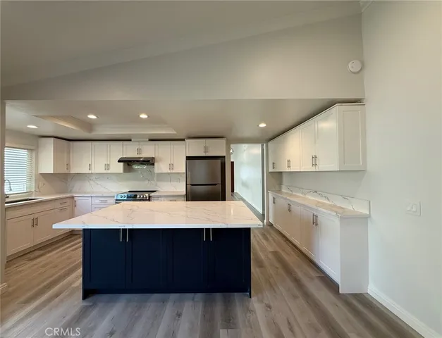 a large kitchen with stainless steel appliances kitchen island a stove and a refrigerator