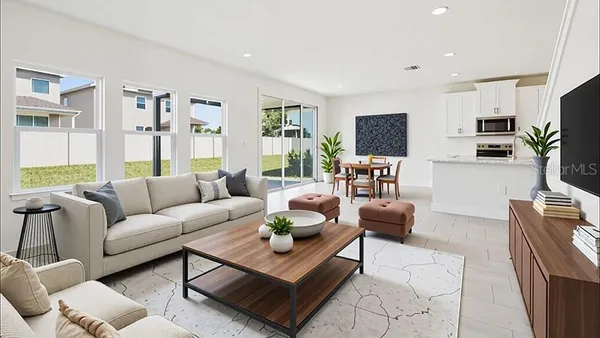a living room with furniture a flat screen tv and a table