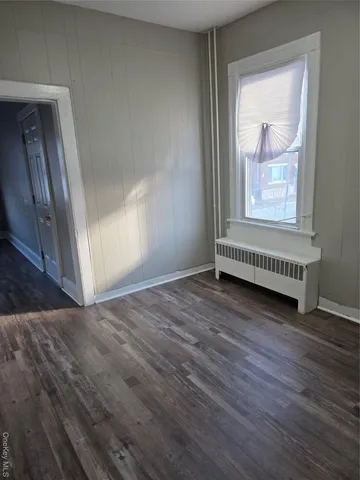 a view of a room with wooden floor and a window