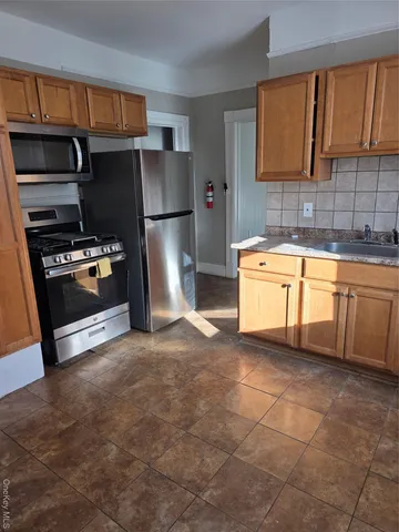 a kitchen with stainless steel appliances granite countertop a refrigerator sink and stove