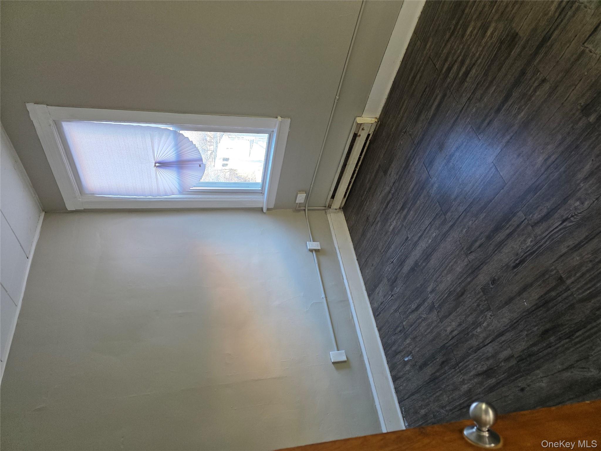 18 Davis Street Poughkeepsie, NY 12601 - Photo 10 of 14 Empty room with a baseboard heating unit and dark wood-type flooring