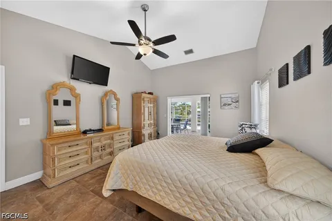 a spacious bedroom with a bed and ceiling fan