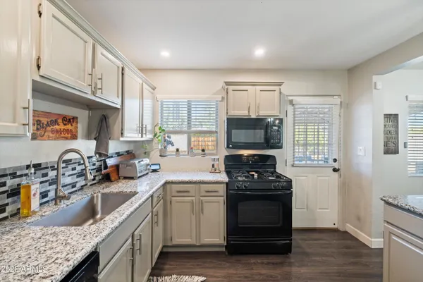 a kitchen with a sink cabinets and wooden floor