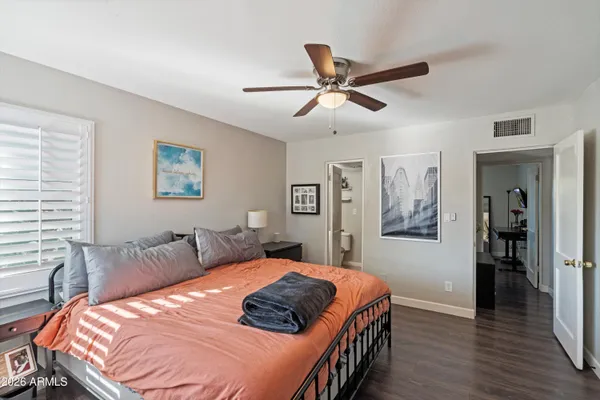 a bedroom with a bed and a flat tv screen on a dresser