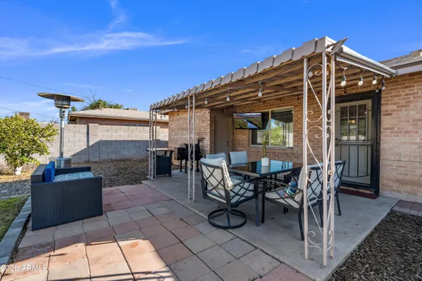 a view of a patio with table and chairs potted plants with large tree