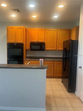 a kitchen with stainless steel appliances a refrigerator and a stove top oven