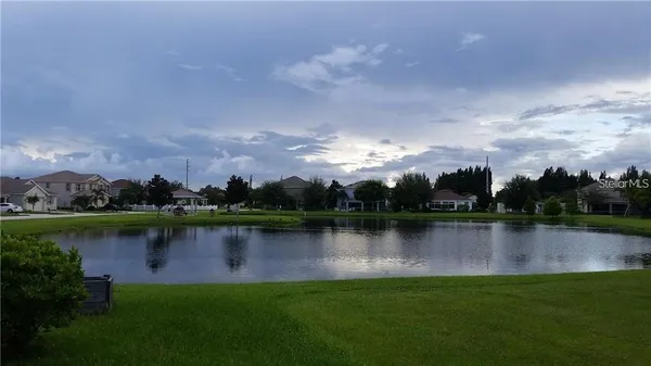 an aerial view of a house with a garden and a lake view