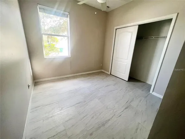 an empty room with windows and closet