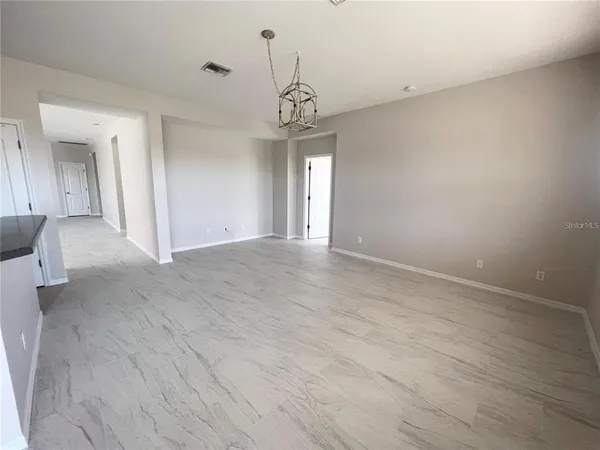 a view of a hallway with wooden floor and chandelier