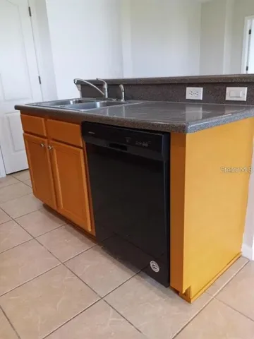 a kitchen with granite countertop a sink and a stove