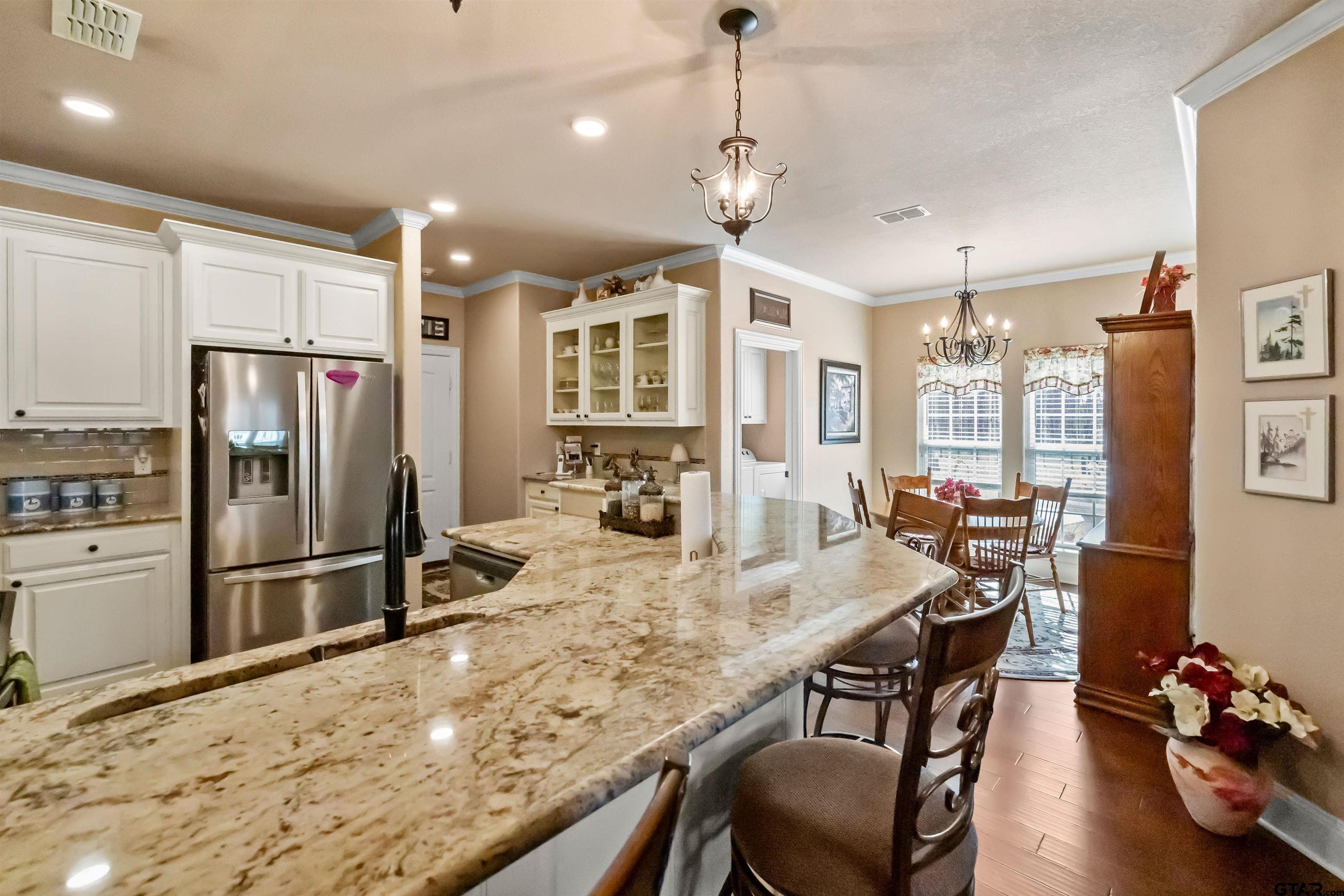 8499 Fm 856 Street Troup, TX 75789 - Photo 19 of 47 a kitchen with stainless steel appliances granite countertop a refrigerator a stove a sink a dining table and chairs with wooden floor