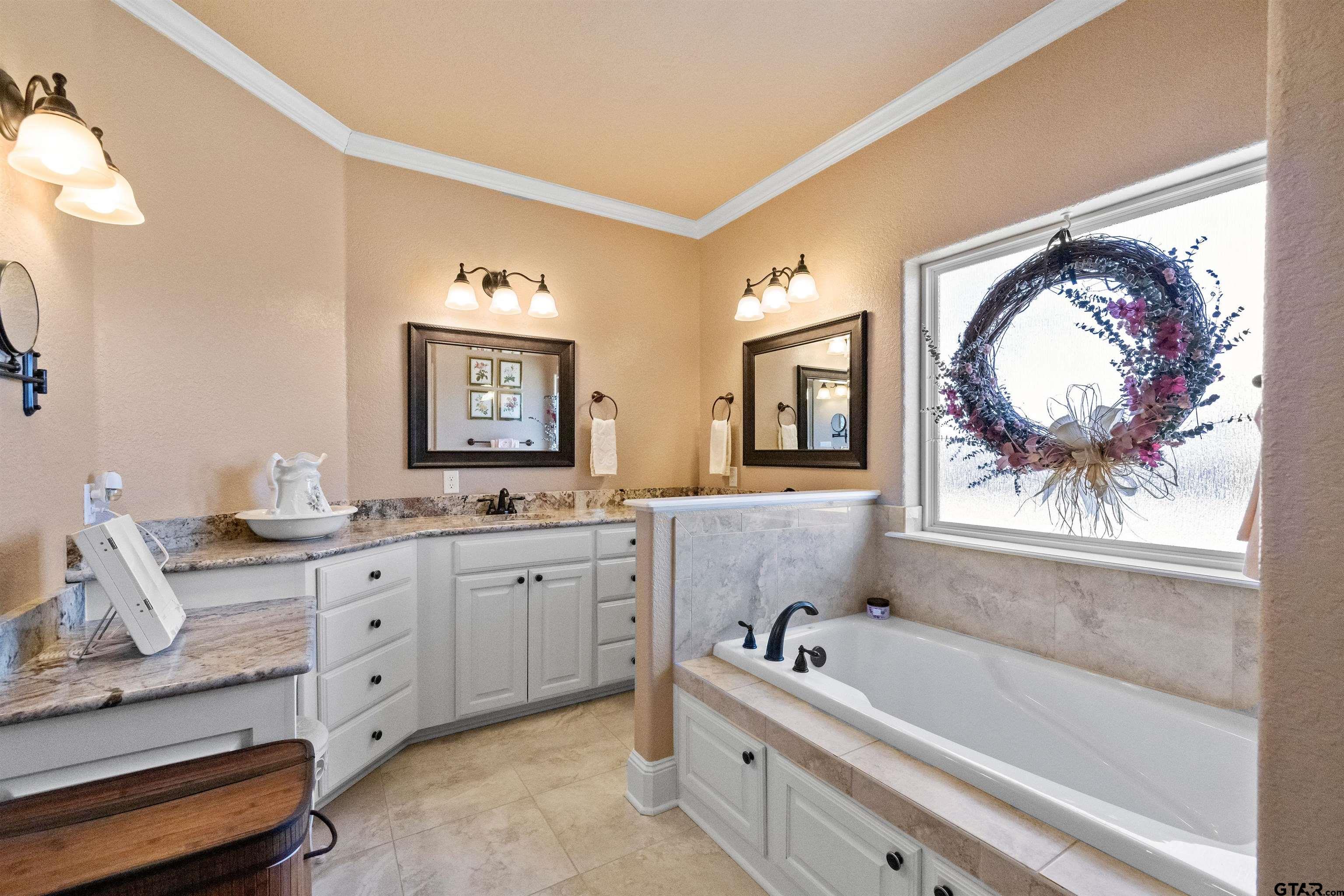 8499 Fm 856 Street Troup, TX 75789 - Photo 26 of 47 a spacious bathroom with a granite countertop tub a double vanity sink and a window