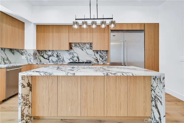 a kitchen with stainless steel appliances granite countertop a sink a refrigerator and a granite counter tops