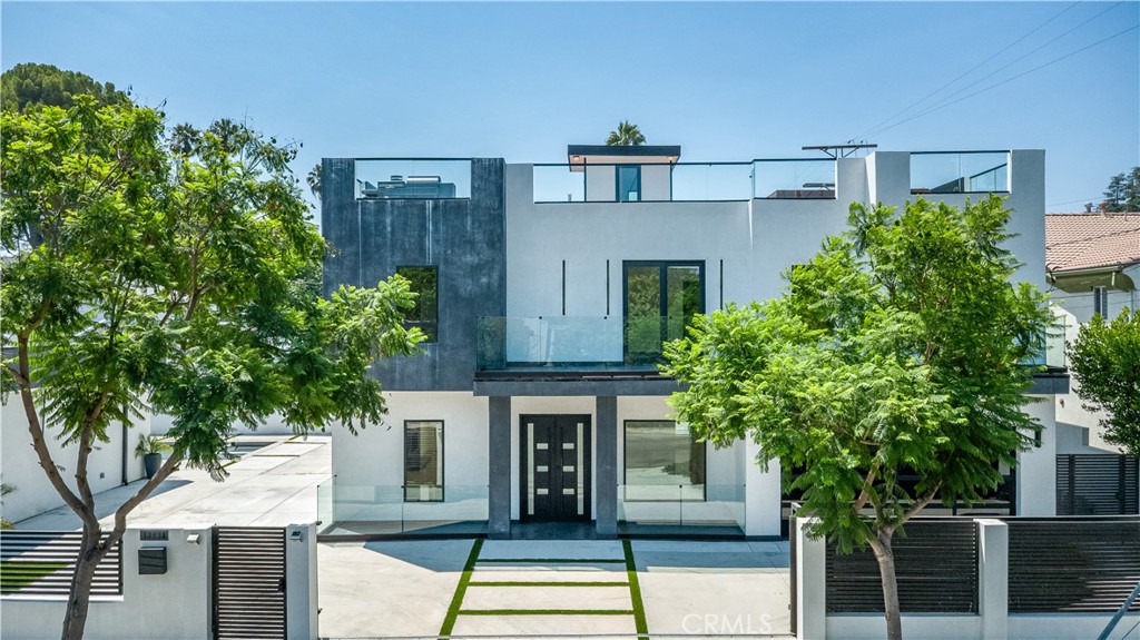 13838 Milbank Street Sherman Oaks, CA 91423 - Photo 2 of 57 a view of a brick house with large windows and a small yard