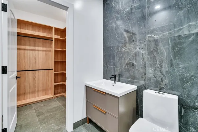 a bathroom with a granite countertop shower a toilet and a sink