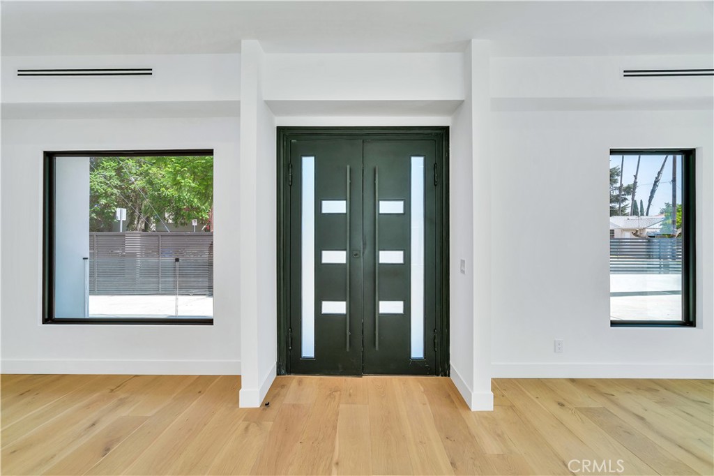 13838 Milbank Street Sherman Oaks, CA 91423 - Photo 4 of 57 a view of a hallway with wooden floor and a fireplace