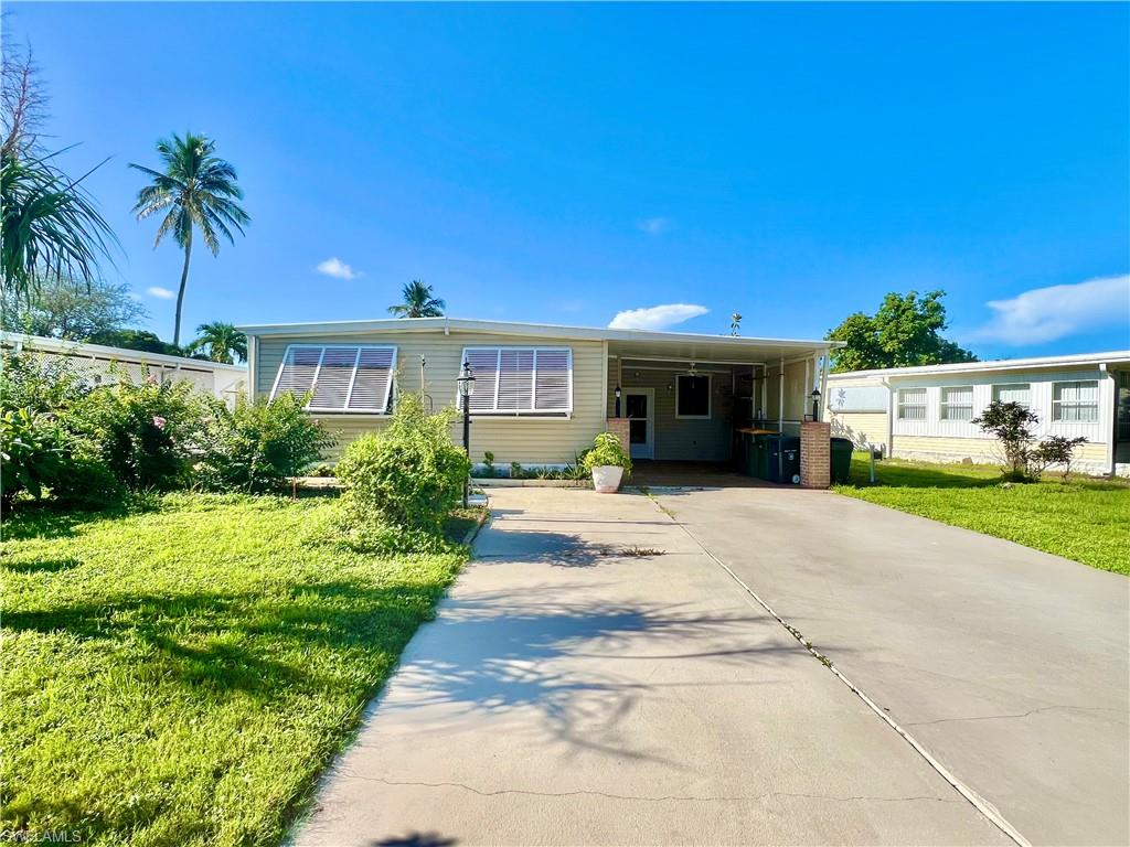 a front view of a house with a yard and potted plants