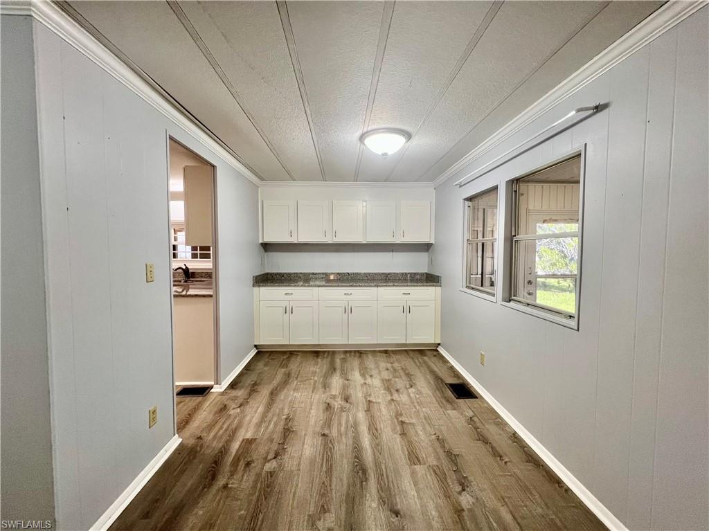 13 Cannes Drive Naples, FL 34112 - Photo 13 of 50 a kitchen with wooden floors and white appliances
