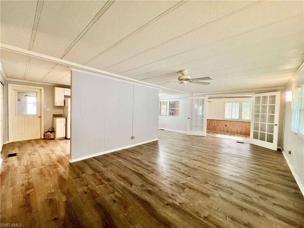 13 Cannes Drive Naples, FL 34112 - Photo 16 of 50 an empty room with wooden floor and windows