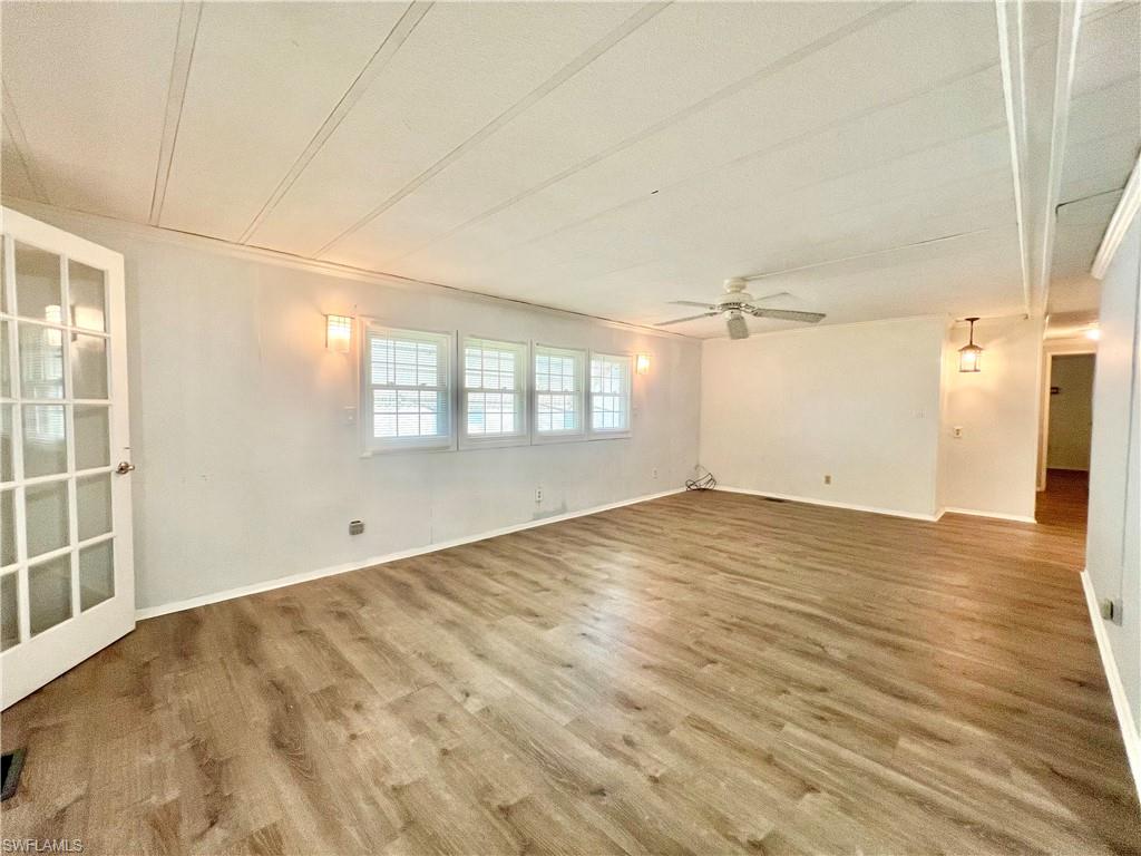 13 Cannes Drive Naples, FL 34112 - Photo 18 of 50 an empty room with wooden floor and windows