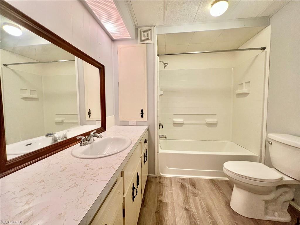13 Cannes Drive Naples, FL 34112 - Photo 25 of 50 a bathroom with a granite countertop sink toilet a mirror and shower