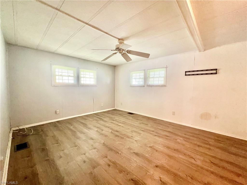 13 Cannes Drive Naples, FL 34112 - Photo 28 of 50 an empty room with wooden floor fan and windows