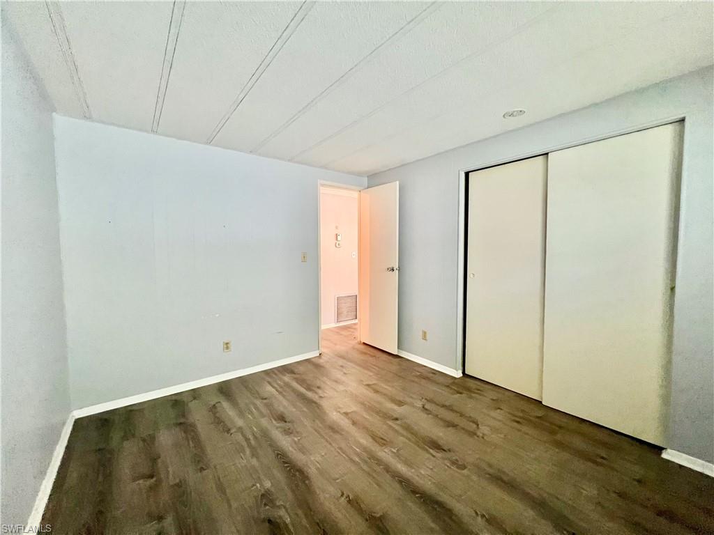 13 Cannes Drive Naples, FL 34112 - Photo 29 of 50 an empty room with wooden floor and windows