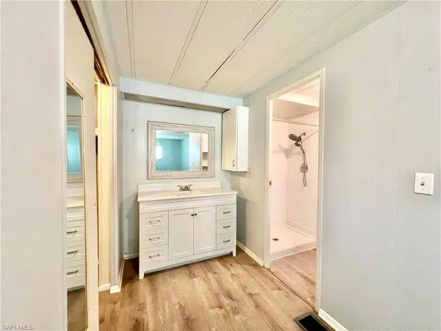 a bathroom with a shower a sink and a mirror