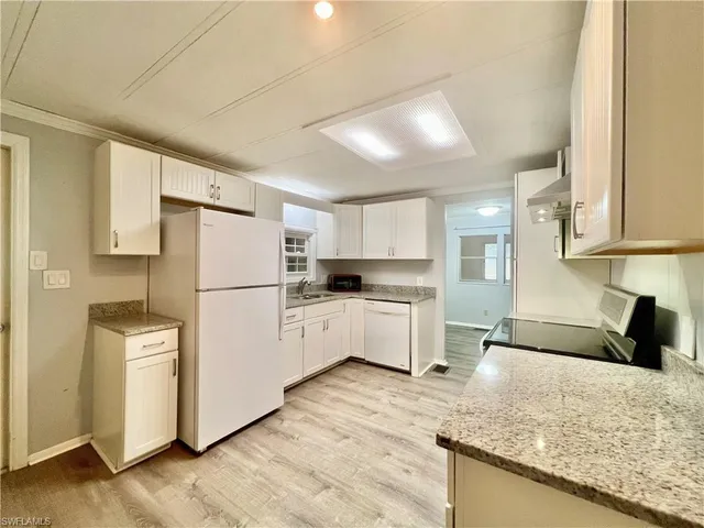 a kitchen with refrigerator cabinets and wooden floor