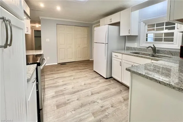 a kitchen with a refrigerator sink and cabinets