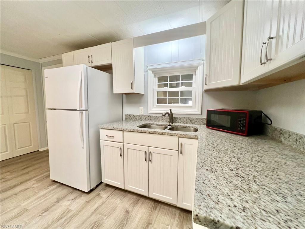 13 Cannes Drive Naples, FL 34112 - Photo 9 of 50 a kitchen with granite countertop a refrigerator sink and cabinets