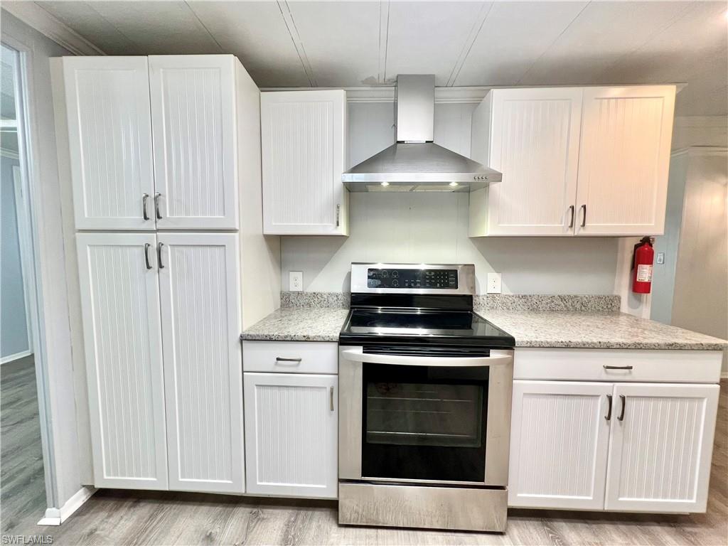 13 Cannes Drive Naples, FL 34112 - Photo 10 of 50 a kitchen with granite countertop white cabinets and white stove
