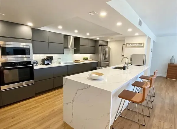 a kitchen with stainless steel appliances kitchen island granite countertop a sink and cabinets