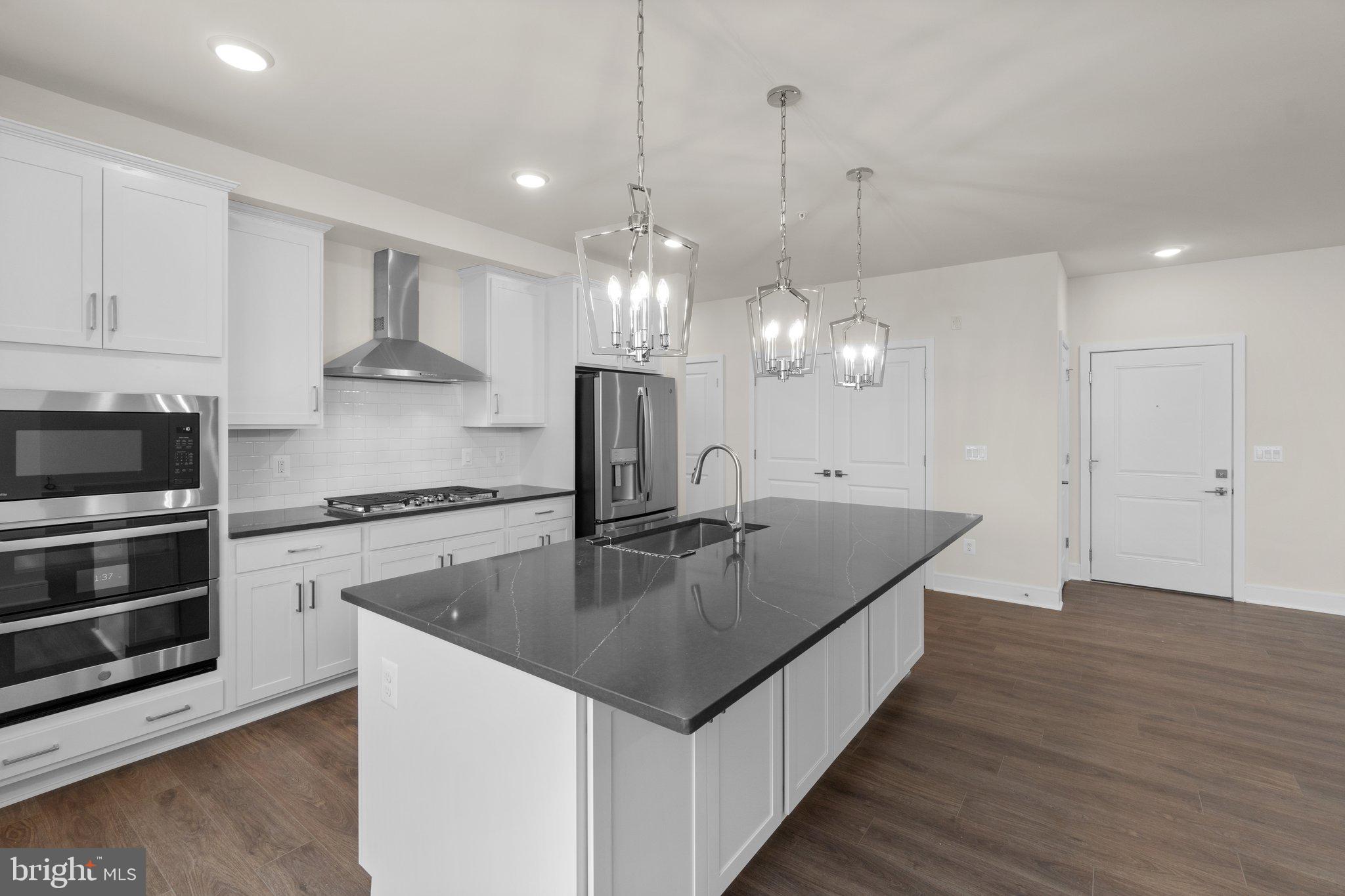 a kitchen with stainless steel appliances granite countertop a sink a oven and a kitchen view